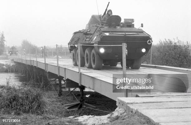 Über eine von Pionieren angelegten Brücke fahren Schützenpanzerwagen der NVA. Im Rahmen einer Übung trainierten die Rückwärtigen Dienste und Pioniere...