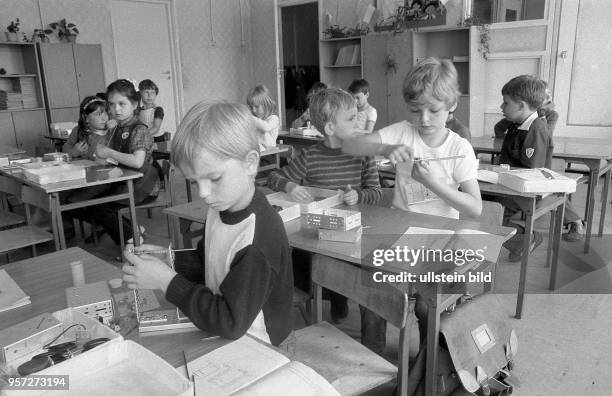 Kinder bei der Montage eines Modells aus Teilen aus einem Metallbaukasten, aufgenommen 1984.