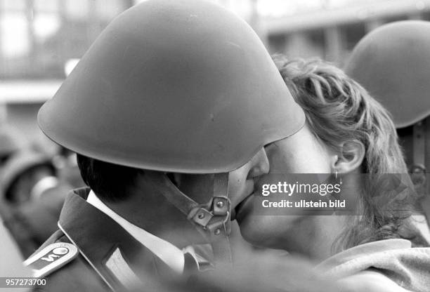 Ein Soldat der Nationalen Volksarmee der DDR tauscht mit einer Frau Zärtlichkeiten aus, aufgenommen am in Berlin . Letztmalig in der Geschichte der...