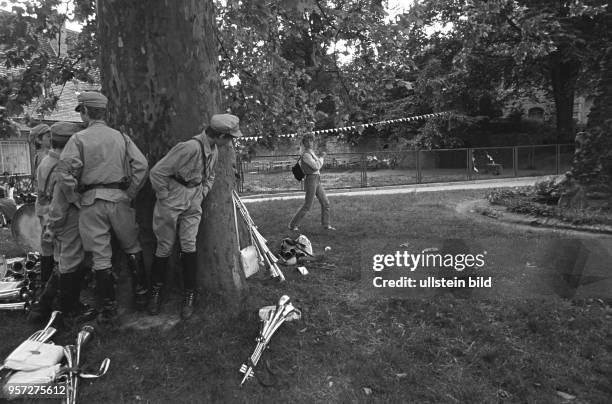 Jugendliche Mitglieder einer Musikkapelle verstecken sich hinter einem Baum vor einer Frau, aufgenommen im Juni 1985 bei einem Fest in Gerbstedt....