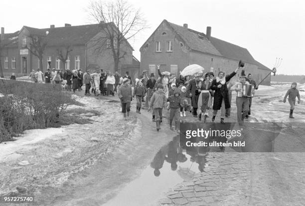 Fasching in Frauenhorst, einem kleinen Stadtteil von Herzberge in Brandenburg. In einem Umzug ziehen Kostümierte und Kinder durch den tristen Ort von...