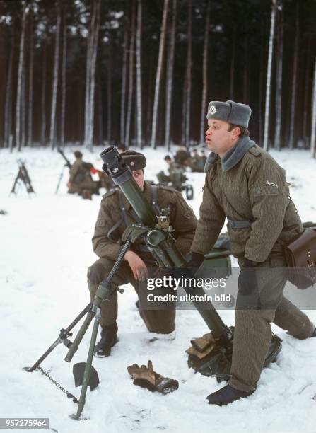 Ein Offizier der Nationalen Volksarmee kontrolliert die Einstellung an einem Granatwerfer bei einer Übung, undatiertes Foto von 1981 bei Torgelow.