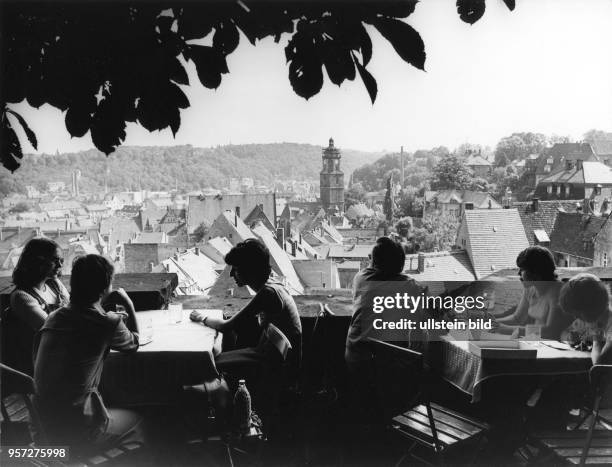 Besucher einer Gaststätte auf dem Burgberg von Meißen genießen die schöne Aussicht auf das Zentrum der Porzellanstadt mit vielen alten Bauwerken,...