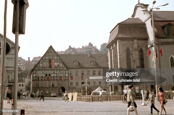 Der Eisenacher Marktplatz mit dem schon in Vorbereitung zum 20. Jahrestag der Republik beflaggten Gebäuden, rechts im Bild die Georgenkirche,...