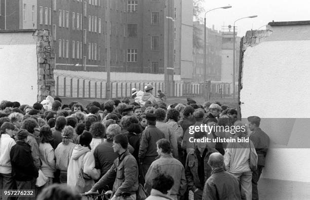 An einer provisorische Öffnung der Berliner Mauer an der Eberswalder Straße warten hunderte Menschen auf den freien Ausgang nach Berlin-West,...