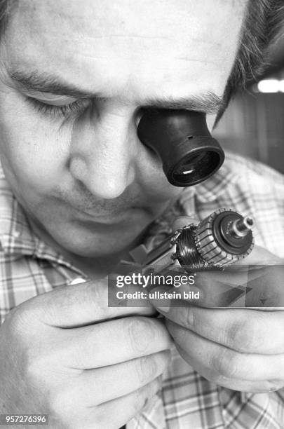 Ein Arbeiter überprüft mit Hilfe einer Augenlupe ein Bohrmaschinen-Bauteil, aufgenommen am im Betriebsteil "Bohrmaschine" des Mansfeld Kombinats bei...