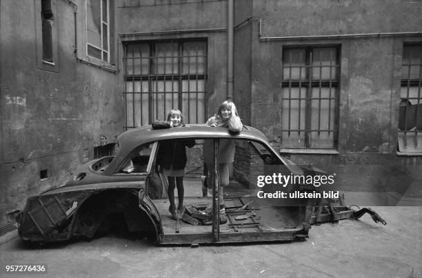 Zwei Mädchen spielen in einem dunklen Hinterhof eines alten, aus der Jahrhundertwende stammenden Mietshauses in der Ackerstraße in Berlin-Mitte,...