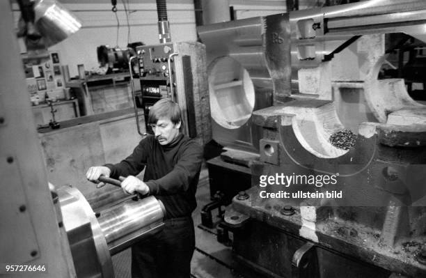In diesem Betrieb in Rostock werden Dieselmotoren hergestellt, aufgenommen 1987. Hier betätigt ein Arbeiter eine der Maschinen.