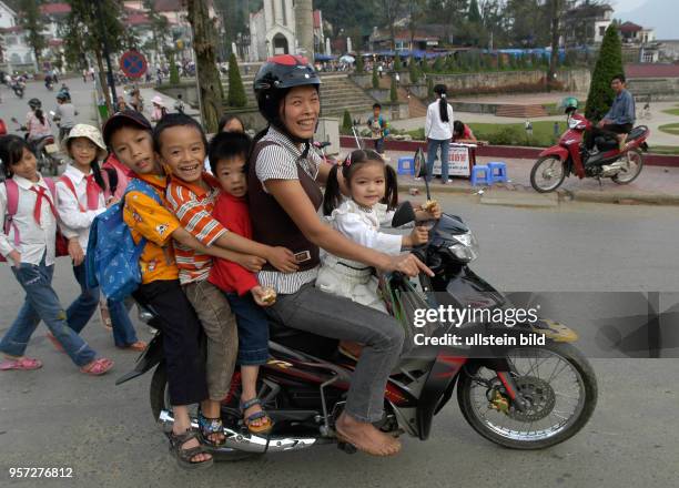 Vor einer Schule im Bergort Sapa in der gleichnamigen Bergregion im Norden Vietnams werden die Kinder von den Eltern meist mit einem Moped abgeholt....