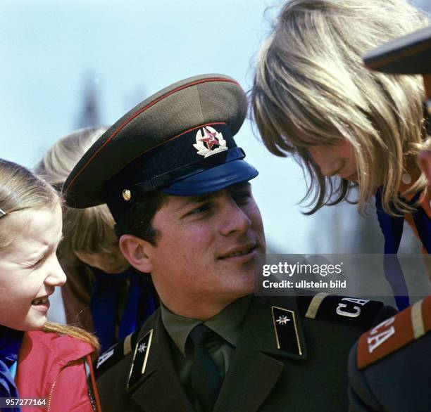 Ein Mitglied des sowjetischen Alexandrow-Ensembles in Uniform und Pioniere der DDR nach einem Auftritt des Chores zum 30. Jahrestag der Befreiung im...