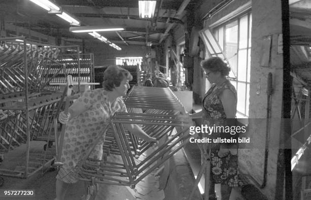 Zwei Arbeiterinnen stellen in einem Produktionsraum des VEB MIFA - Werk Sangerhausen, Betrieb des IFA-Kombinats für Zweiradfahrzeuge, Fahrradrahmen...