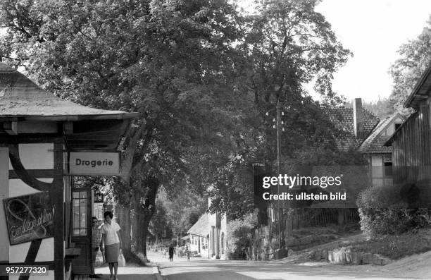 Straßenszene im Harz-Ort Schierke, undatiertes Foto von 1960. Auf einer Tafel an der Drogerie werden Einlegesohlen angeboten.