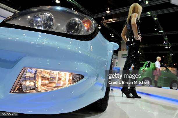 Model Kelly McManus of Grosse Pointe Woods, Michigan poses with the CT&T C2 C Square electric vehicle displayed during the press preview for the...