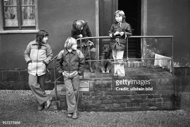 Eine Gruppe Kinder steht am in einem Hauseingang zu einem der Reihenhäuser in der Wohnsiedlung der Kupferhütte Helbra und langweilt sich. Die Mütter...