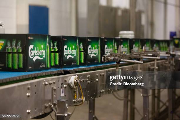 Boxes containing bottles of Carlsberg beer move along the packing line during the labeling process at the Baltika Breweries LLC plant, operated by...