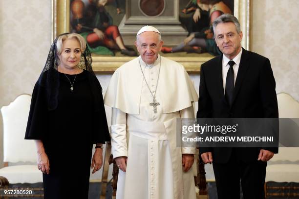 Pope Francis poses for a photo with Romania's Prime Minister Viorica Dancila and her husband Cristinel Dancila during a private audience in the...