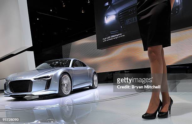 Model stands near the Audi E-Tron electric sports car is during the press preview for the world automotive media North American International Auto...