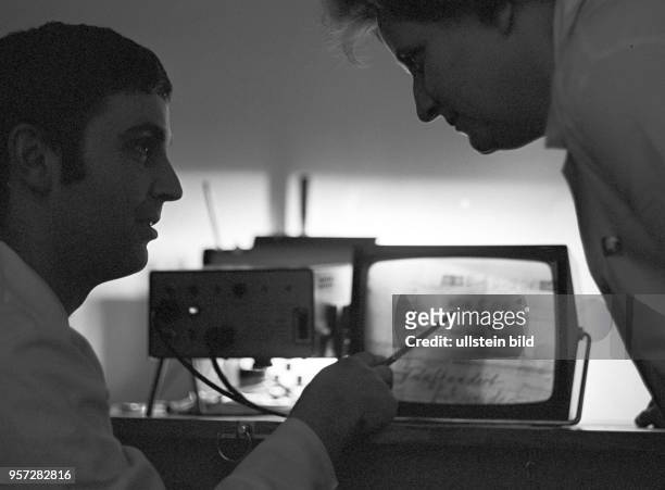 Graphologen des Kriminaltechnischen Instituts der Polizei in Berlin untersuchen einen Scheck auf Fälschung, aufgenommen im April 1970.