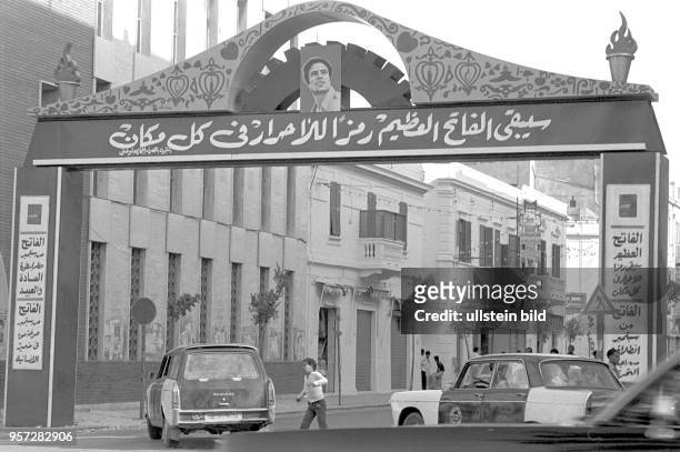 Ein stilisiertes Tor mit arabischer Schrift und dem Porträs des libyschen Revolutionsführer Oberst Muammar Abu Minyar al-Gaddafi überspannt eine...
