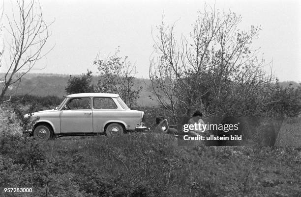 Seinen Pkw vom Typ Trabant hat dieses Paar kurzerhand abgestellt, nun gönnt es sich am Straßenrand sitzend eine Erholungspause, aufgenommen im Juli...