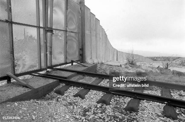 Ein geschlossenes Metalltor in der Grenzmauer am Brocken versperrt die Schiene der Brockenbahn zum Gipfel, aufgenommen im Januar 1990. Der Brocken im...