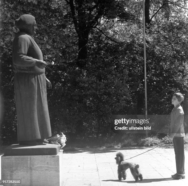 Eine Frau mit Hund steht vor dem von Bildhauer Walter Arnold geschaffenen Denkmal von Clara Zetkin im gleichnamigen Park in Leipzig, undatiertes Foto...