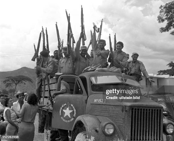 Revolutionäre der Bauernmiliz, Landarbeiter in Uniform, kommen mit einem Lkw in ein Dorf und werden begrüßt - lachend halten sie ihre Gewehre über...