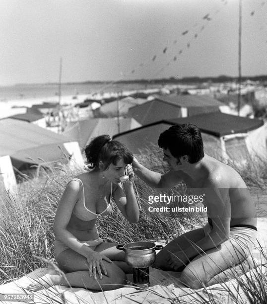 Ein junges Paar aus Thüringen verzehrt sein Mittagessen in den Dünen, aufgenommen im Juli 1970 im Ostseebad Prerow auf dem Darß. Wie so viele...