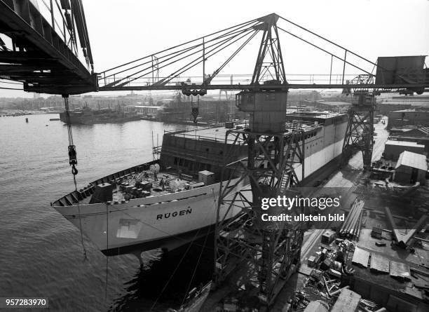 Die Eisenbahn-Kraftfahrzeug-Fähre "Rügen" am Ausrüstungskai der Rostocker Neptun Werft, aufgenommen 1971. Die "Rügen" ist das dritte kombinierte...