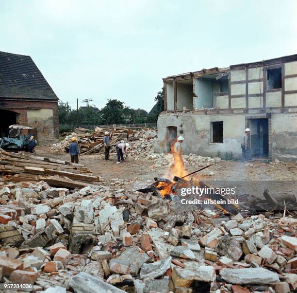 Alte Holzbalken abgerissener Gebäude werden verbrannt, Mauern niedergerissen, der Ort Magdeborn weicht dem anrückenden Braunkohletagebau Espenhain,...