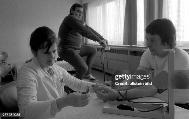 Ärztin Dr. Andrea Seitz vom Sanatorium in Heiligendamm misst im FDGB-Erholungsheim "Waterkant" in Börgerende den Puls eines Kurpatienten, aufgenommen...