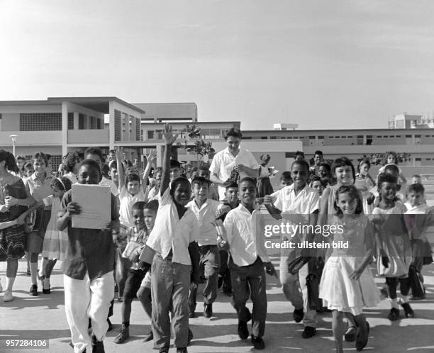 Lachende und winkende Kinder vor einer neugebauten Schule in Havanna , aufgenommen 1962.