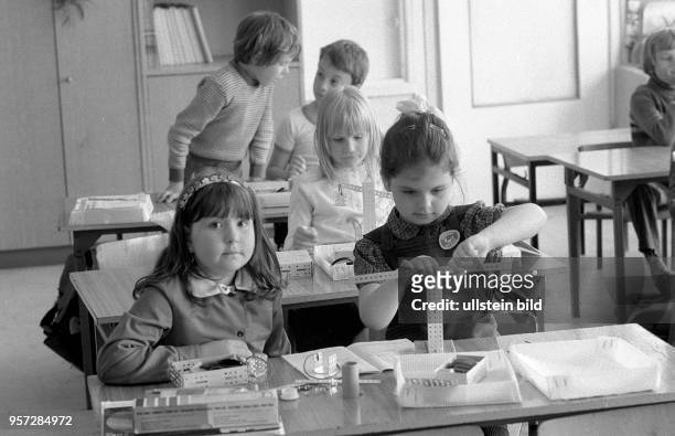 Kinder bei der Montage eines Modells aus Teilen aus einem Metallbaukasten, aufgenommen 1984.