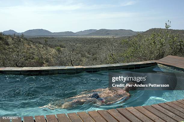 Guests have drinks as the sun sets in the Madikwe game reserve on September 11 in Madikwe, South Africa. The lodge is community owned by a village...