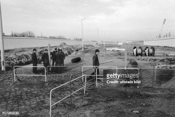 An einer provisorische Öffnung der Mauer an der Eberswalder Straße haben Grenzsoldaten der DDR Sperrgitter aufgestellt, um den Übergang der Menschen...