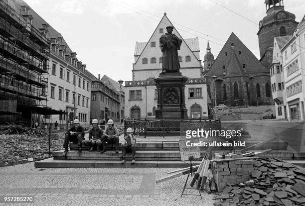 Bauarbeiter sitzen zu Füßen des von Rudolf Siemering geschaffenen und 1883 enthüllten Lutherdenkmals auf dem Marktplatz in Eisleben und gönnen sich...