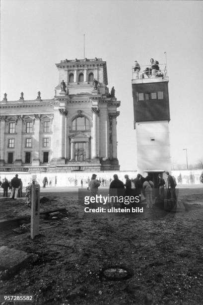 Menschen besichtigen am die Berliner Mauer am Reichstagsgebäude und erklimmen auch einen erhaltenen gebliebenen Wachturm der Grenztruppen der DDR,...