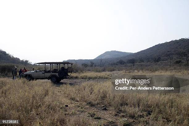 Guests have drinks as the sun sets in the Madikwe game reserve on September 11 in Madikwe, South Africa. The lodge is community owned by a village...