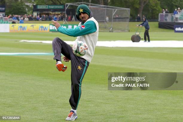 Pakistan's Saad Ali plays football with teammates as groundsmen work on the wet pitch at Malahide cricket club, in Dublin as the start of play is...