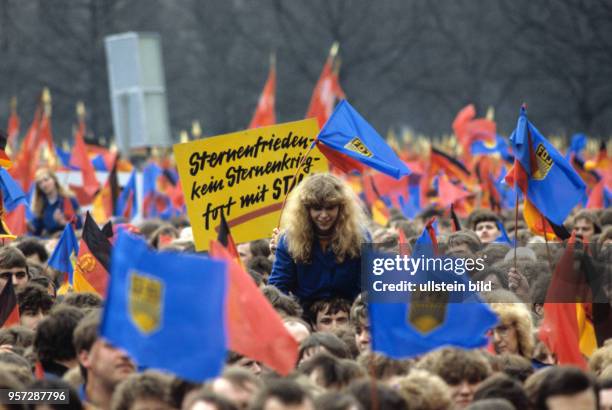 FDJler mit Fahnen und einer Losung "Sternenfrieden - kein Sternenkrieg..." bei einer Veranstaltung im Rahmen des XI. Parteitages der SED im April...