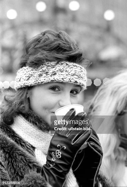 Eine junge Dresdnerin wärmt sich beim Bummeln über den Striezelmarkt auf dem Altmarkt in Dresden mit einem Heißgetränk auf, aufgenommen zur...