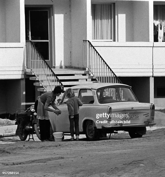 Eine Frau beim Waschen ihres Pkw vom Typ Trabant, aufgenommen im Juni 1983 in der Neubauwohnsiedlung in der Helbraer Straße in der Lutherstadt...