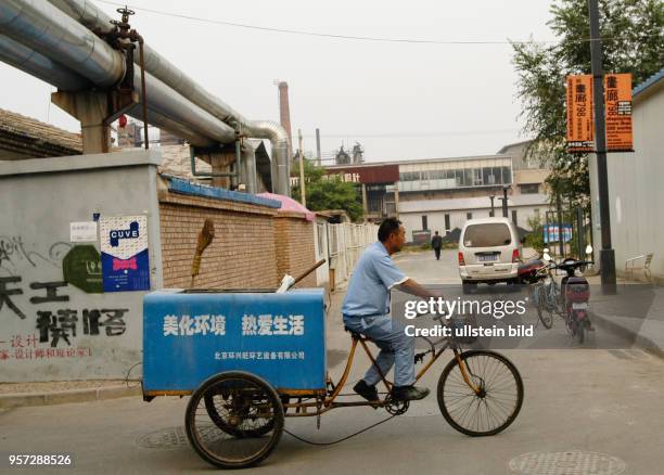 China - Peking / Ein Fahrradfahrer mit Transportanhänger im Art-Viertel von Peking, aufgenommen im Oktober 2009. Kunst spielt in Peking, der...