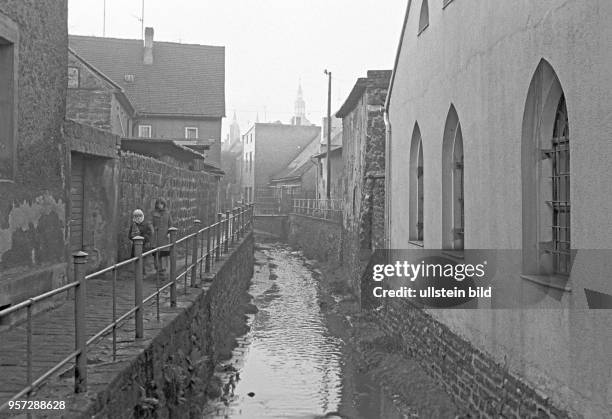 Das Flüßchen "Die böse Sieben" fließt zwischen alten Häusern in der Gegend um den Lutherweg in Eisleben, aufgenommen im November 1981. In...