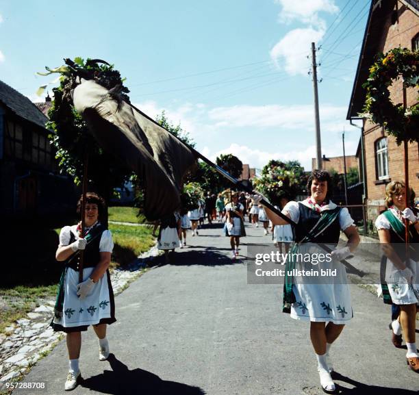 Frauen tragen Kränze und eine Fahne des 1896 gegründeten Jungfrauen-Vereins beim Volksfest Grasedanz in Hüttenrode im Harz, undatiertes Foto vom...