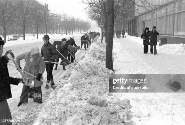 Freiwillige schaufeln Schnee von der Fahrbahn der Straße Unter den Linden, undatiertes Foto vom Februar 1979. Extreme Kälte und viel Schnee...