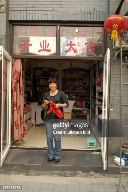 Der 60. Jahrestag der Gründung der Volksrepublik, im Oktober 2009 gefeiert, brachte auch für Peking viel Neues. Eine Verkäuferin steht vor einem der...