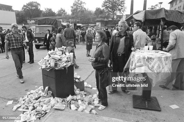 Ein überquellender Abfallbehälter neben einem Stehtisch bei einem Straßenfest im Wohngebiet Ernst-Thälmann-Park in Berlin , aufgenommen 1986. Das...