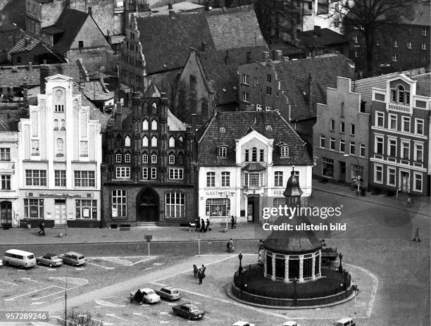 Blick auf den Marktplatz der Hansestadt Wismar mit der 1602 fertiggestellten Wismarer Wasserkunst sowie den Bürgerhäusern, aufgenommen im Mai 1974....