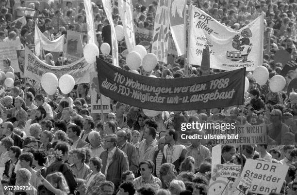 Demonstranten tragen auf der Demonstration am 1. Mai 1988 in der Karl_Marx_Allee in Berlin Transparente und Plakate mit der Aufschrift "110 Wohnungen...